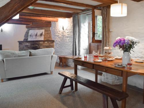 a living room with a table and a couch at Ty Ceffylau - Uk46190 in Llanybydder