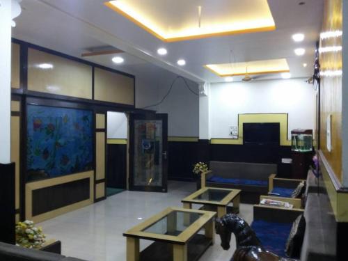 a living room with two tables and a large aquarium at Hotel Kanha International in Dhār