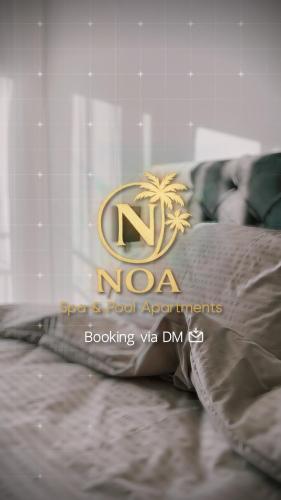 a sign on a bed with a palm tree on it at NOA Apartaments Pool&Spa in Kragujevac