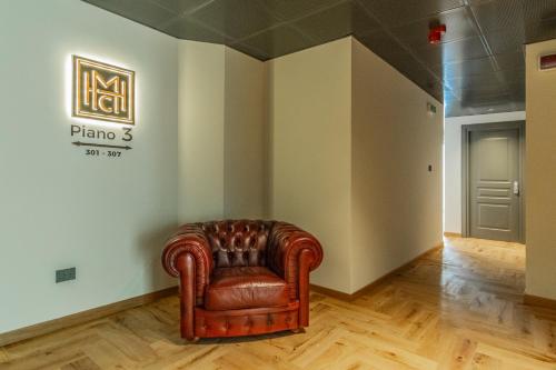 a leather chair in a room with a sign on the wall at Madi city Hotel in LʼAquila