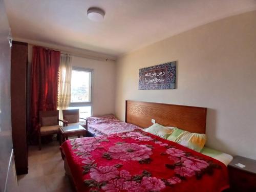 ein Schlafzimmer mit einem roten Bett mit Blumen darauf in der Unterkunft Aqua view Park North coast ---91km in El-Alamein