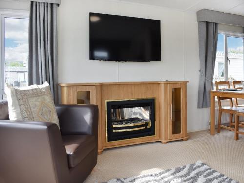 a living room with a fireplace with a tv above it at Uk47339 - Evergreen in Plumbland