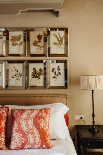 a bedroom with a bed with a bunch of pictures on the wall at Relais Sant'Elena in Bibbona