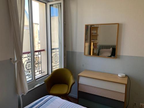 - une chambre avec un miroir et une chaise à côté d'une fenêtre dans l'établissement Artist 40m2 Montmartre district, à Paris