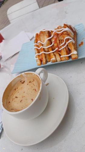 una taza de café y un plato con un pastel en Hotel Shiv Palace Yoga World Retreat, en Rishīkesh