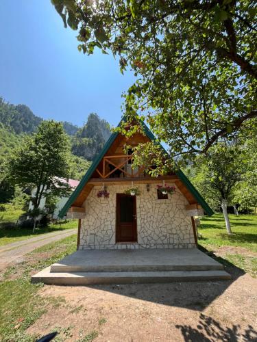a small house with a green roof and a door at Guesthouse Stanisic in Mojkovac