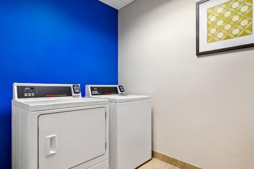 a room with a washing machine and a blue wall at Holiday Inn Express & Suites Jacksonville South East - Medical Center Area by IHG in Jacksonville