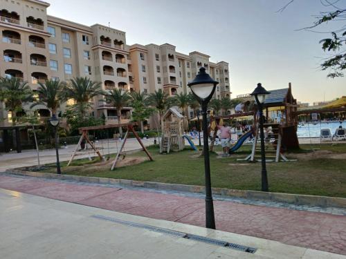 a playground at a resort with a park with swings at Aqua view North coast-الكيلو 91- in El Alamein