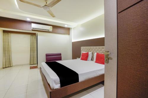 a bedroom with a bed with red pillows at Collection O Sapna in Mire