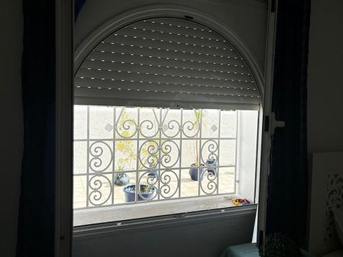 an arched window with vases on a balcony at Modern 3-Bedroom Apartment in Gated Residence with Pool in Yasmine