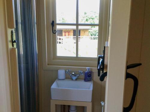 a bathroom with a sink and a window at Beeches Shepherd Hut in Harleston