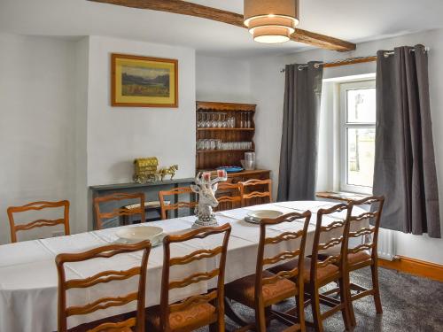 a dining room with a white table and chairs at Uk46833 - Low Hollas Farmhouse in Threlkeld