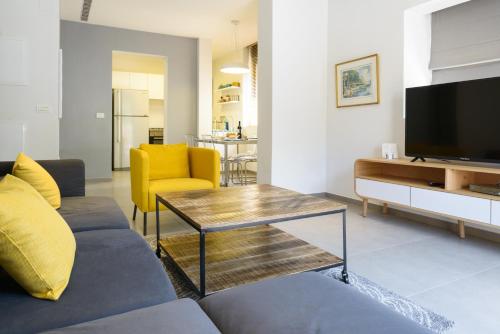 a living room with a couch and a television at Sunny Luxury Apartments in Tel Aviv