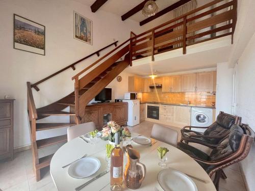 une salle à manger avec une table et un escalier dans l'établissement Appartement 2 pièces avec mezzanine, terrasse et parking, à 500m de la plage - Fréjus - FR-1-226A-42, à Fréjus