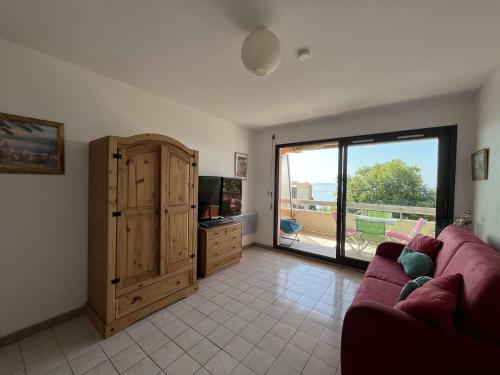 un salon avec un canapé et une grande fenêtre dans l'établissement Studio cosy au Lavandou avec terrasse et parking - FR-1-308-73, au Lavandou