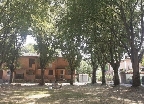 a park with a bench and trees in front of a building at Villetta nel verde di Ferrara in Pontelagoscuro