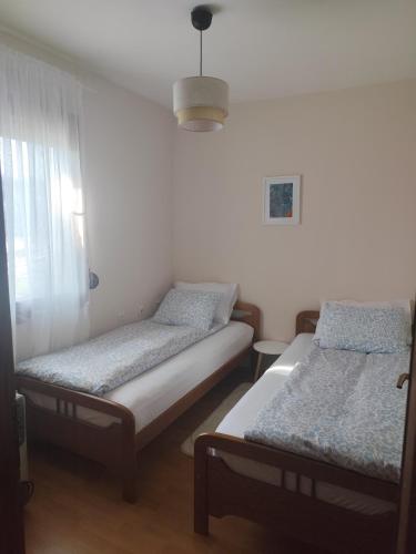 a room with two beds and a window at Nikolija in Žabljak