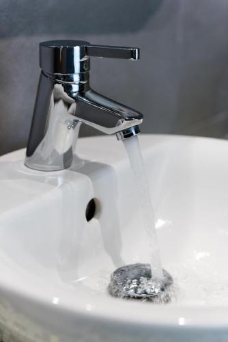 a sink with water running from a faucet at family love suite in Santorini