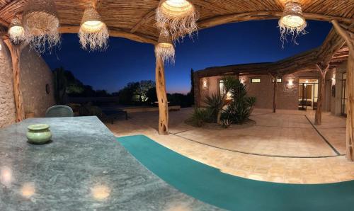 an outdoor patio with a table and a wooden ceiling at Dar Tikida - Luxury Beach Villa - 8 people in Sidi Kaouki