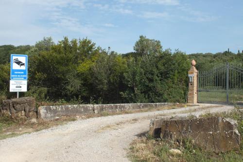 a sign on a dirt road next to a gate at Casetta dell`Uliveto in Macchiascandona