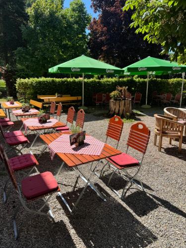 a group of tables and chairs with green umbrellas at Gasthaus Jungwirth - Family Boutique Pension in Wanghausen