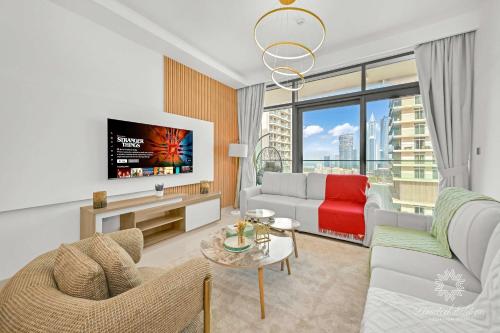 ein Wohnzimmer mit Sofa und Fernseher in der Unterkunft Luxury 2 Bedroom Apartment - Private Beach - Emaar Beach Vista in Dubai