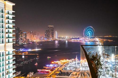 ein Blick auf eine Stadt bei Nacht mit einem Riesenrad in der Unterkunft Luxury 2 Bedroom Apartment - Private Beach - Emaar Beach Vista in Dubai