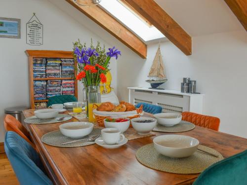 a wooden table with bowls of food on it at Bayview Cottage in Penzance