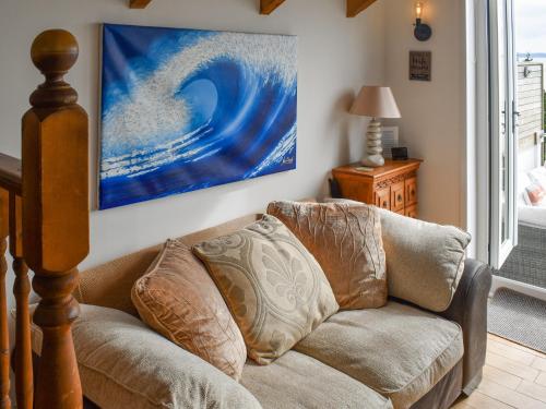 a living room with a couch and a painting on the wall at Bayview Cottage in Penzance