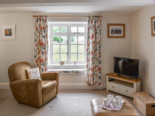 a living room with a chair and a window at 1 The Old Corn Mill in West Burton