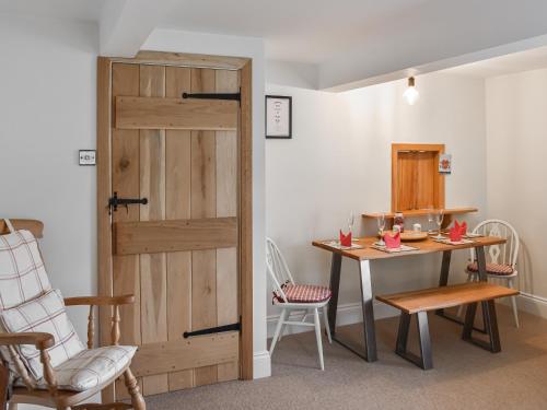 a door leading into a dining room with a table and chairs at 1 The Old Corn Mill in West Burton