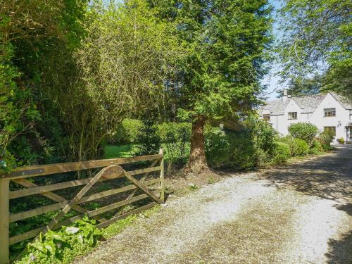 a wooden fence in front of a house with a tree at Treetops in Woodchester