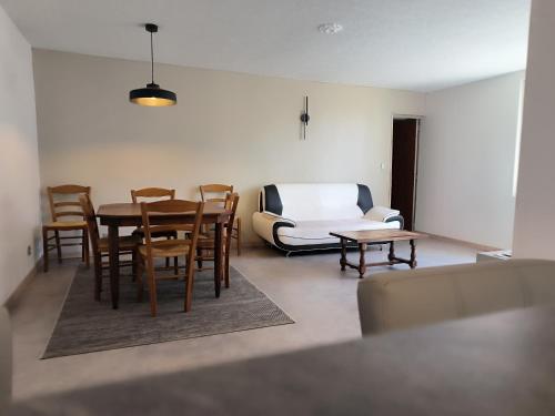 un salon avec une table, des chaises et un canapé dans l'établissement maison de centre ville, à Champagnole