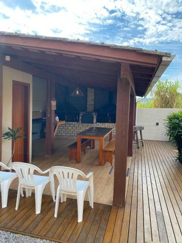 a patio with a table and chairs on a deck at Pousada Hanalie by Easy Hotéis in Praia do Rosa