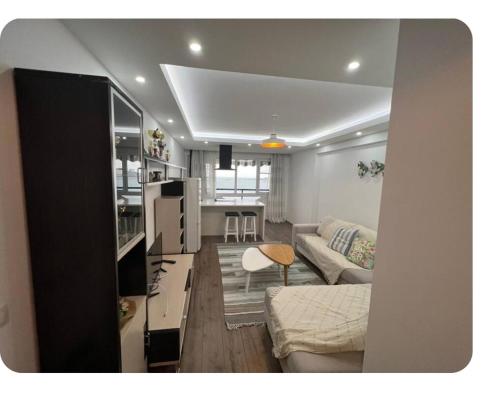 una sala de estar con un sofá y una mesa en Brecani Apartment, en Shëngjin