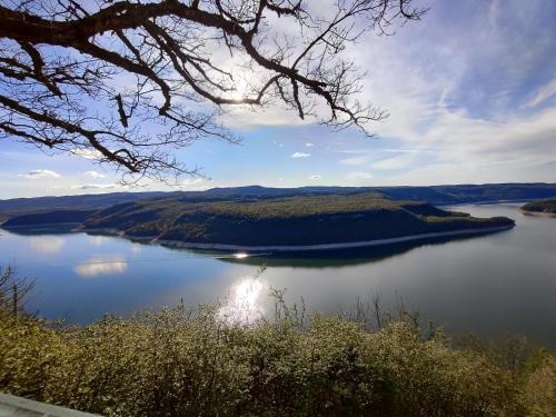 a view of a large lake with the sun shining on it at Appartement du Pré Nouveau in Prénovel