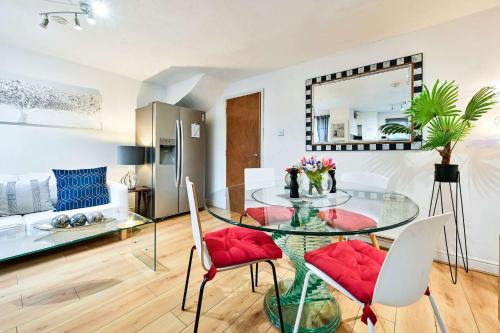 a dining room with a glass table and red chairs at Destination London Docklands Riverside in London