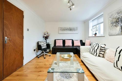a living room with a couch and a table at Riverside Townhouse with Private Garden in London