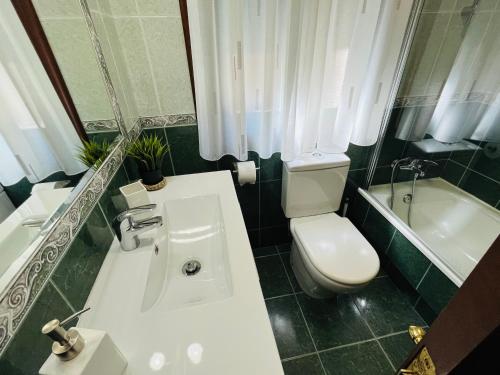 a bathroom with a toilet and a sink and a tub at Casa da Fonte in Combarro