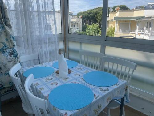 une table et des chaises dans une pièce avec une fenêtre dans l'établissement Apartament In Lalzi Bay, Lura 1 Complex, à Draç
