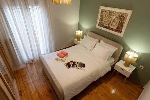 a bedroom with a white bed with two books on it at Prime location - 2 bd Boutique apartment in Thessaloniki