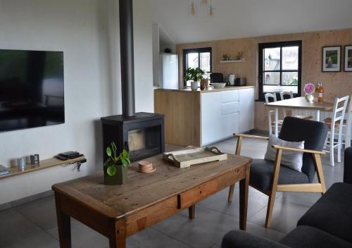 a living room with a table and a fireplace at La clef des bois in Paliseul
