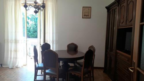 a dining room table with chairs and a television at Villetta nel verde di Ferrara in Pontelagoscuro