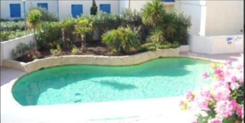 une petite piscine en face d'un bâtiment dans l'établissement Le Grand bleu, à Valras-Plage