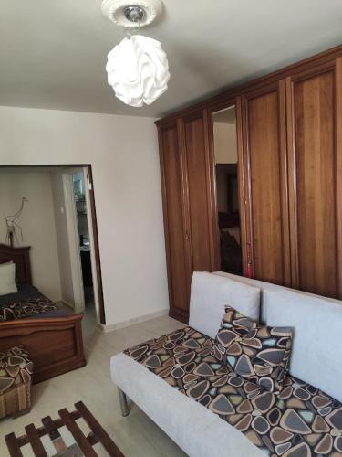 a bedroom with a couch and a chandelier at Willa Sandal in Eilat