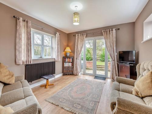 a living room with a couch and a tv at Primrose Cottage - Uk48563 