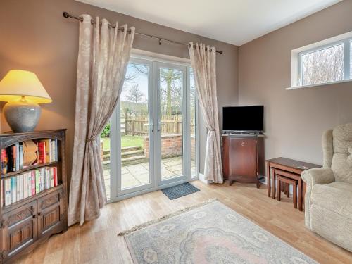 a living room with a sliding glass door at Primrose Cottage - Uk48563 