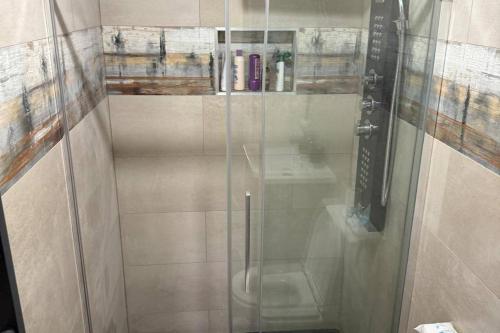 a shower with a glass door in a bathroom at Cherry Chirp Cottage in County Fermanagha in Garrison