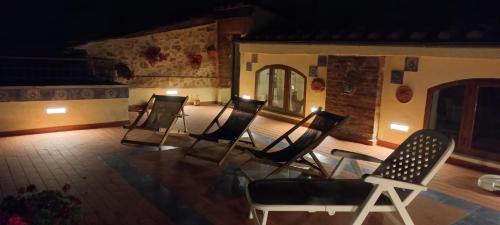 a group of chairs sitting on a patio at night at La Casa del Gallo in Radicondoli