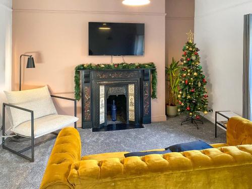 a living room with a couch and a christmas tree at Pavilion Mews in Buxton